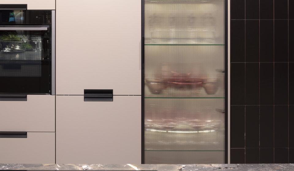 Geriffelte Glasscheiben in Vitrinenschrank in einer ansonsten altrosa gehaltenen Ballerina-Küche